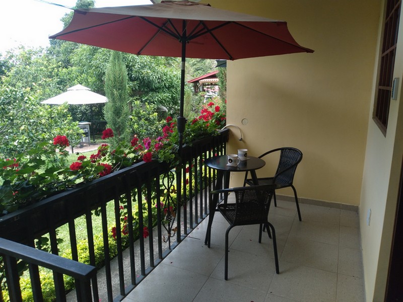 A terrace with table and two chairs and coffee pots